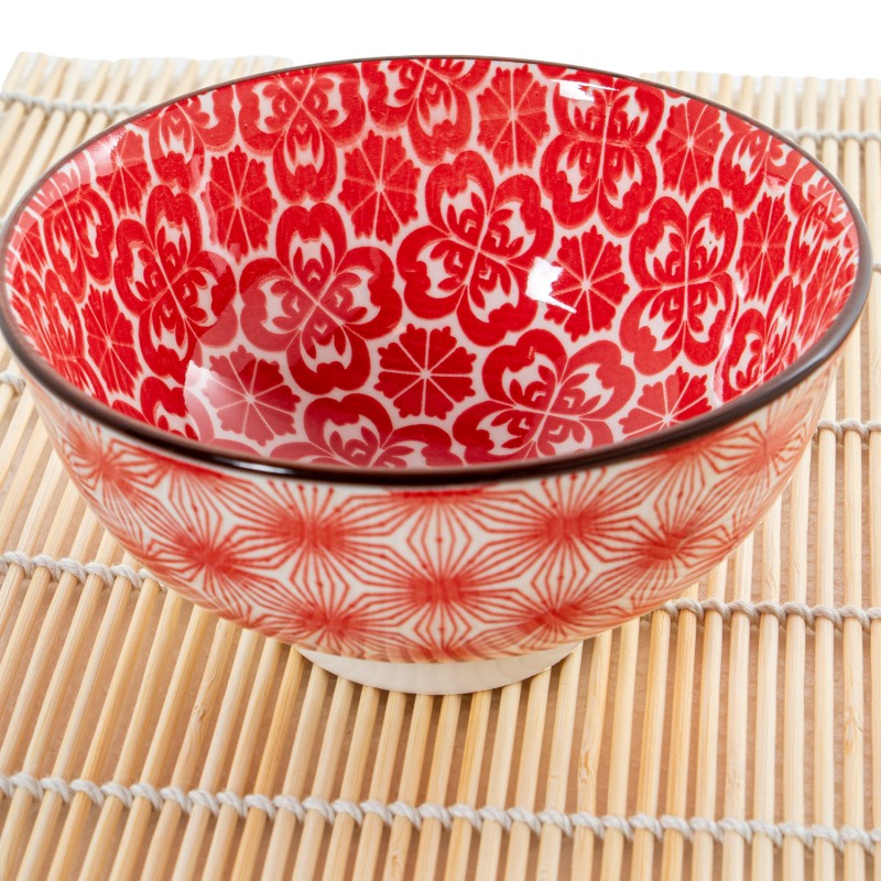 Primer plano del cuenco de porcelana mostrando el detalle del diseño floral rojo y el acabado brillante