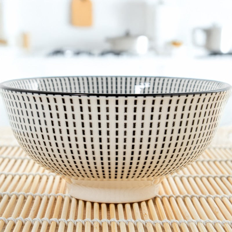 Cuenco de porcelana con diseño geométrico gris en ambiente de cocina, sobre salvamanteles de bambú