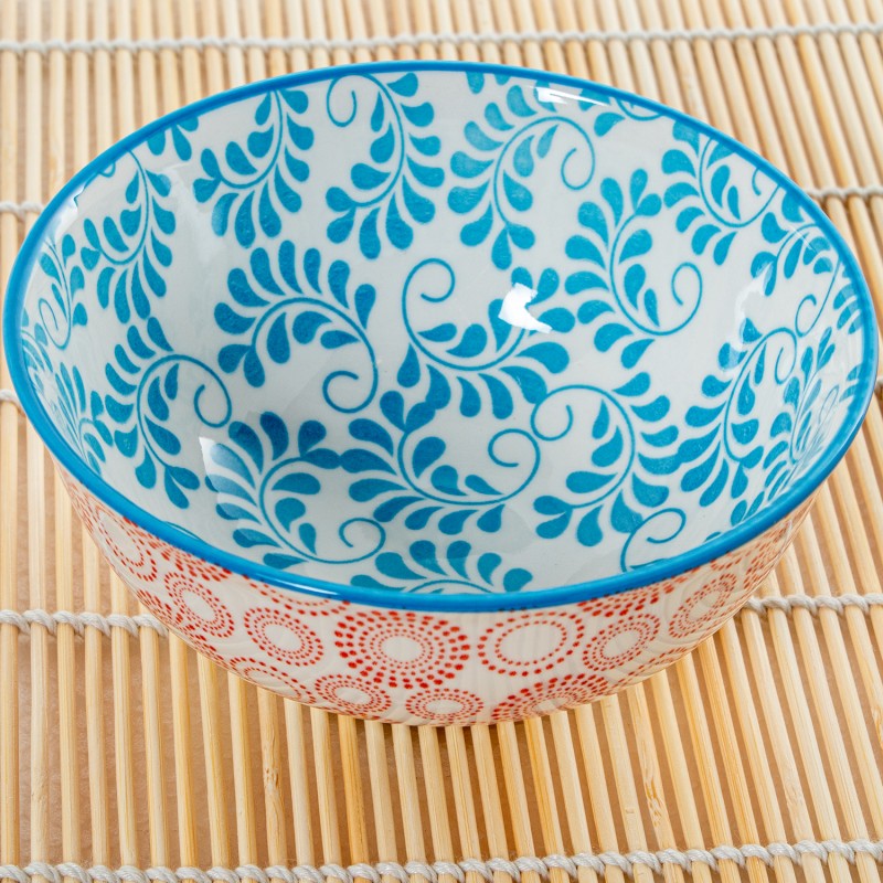 Vista amplia del interior del cuenco de porcelana con diseño floral azul turquesa sobre salvamanteles de bambú