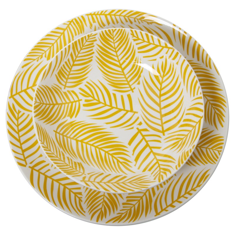 Vista superior de tazón sobre plato llano de porcelana amarilla con estampado de hojas