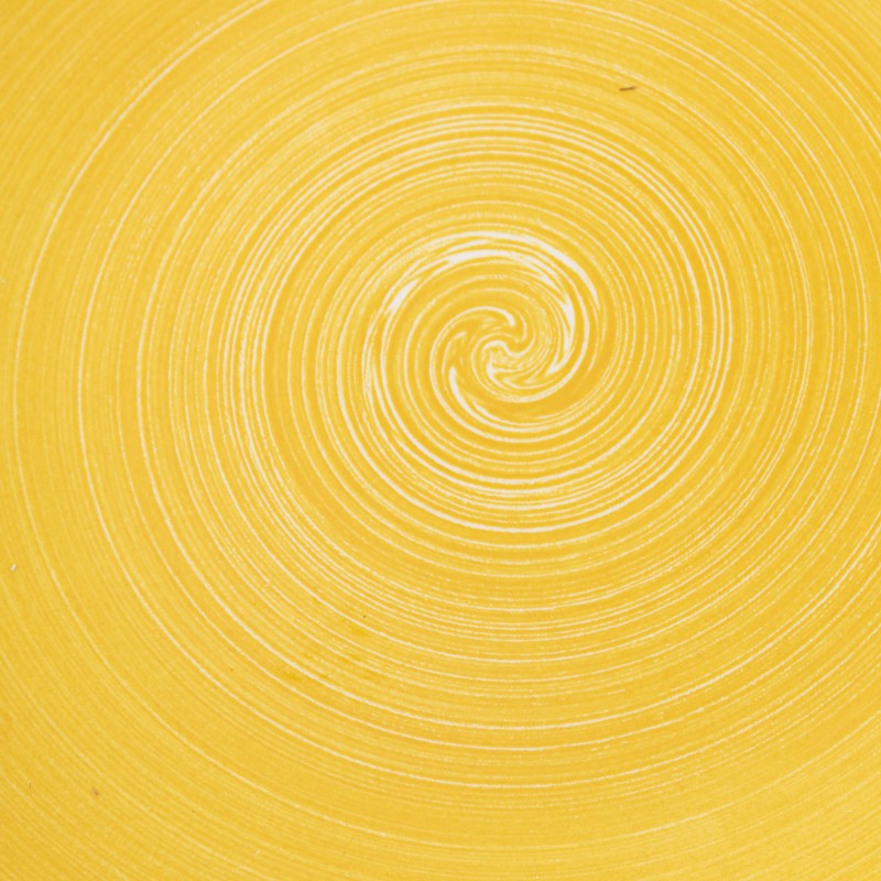 Detalle macro del acabado esmaltado en amarillo liso con efecto espiral del plato de postre