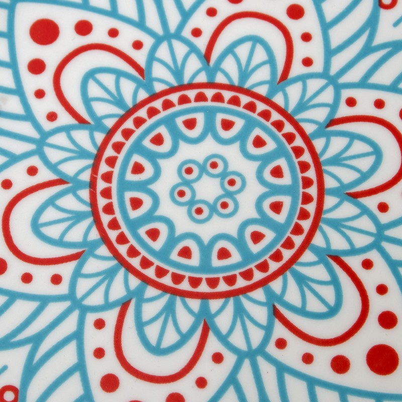 Primer plano macro del centro del patrón mandala en tonos azul turquesa y rojo de la vajilla de porcelana