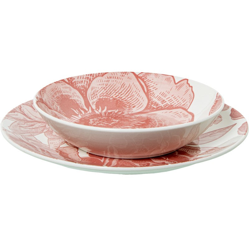 Tazón de porcelana con motivo floral rosa sobre plato llano a juego, vista frontal sobre fondo blanco