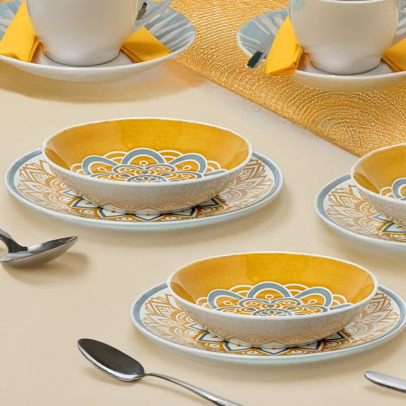 Tazones de porcelana con diseño mandala amarillo servidos en mesa con cucharas, ambientación de comedor