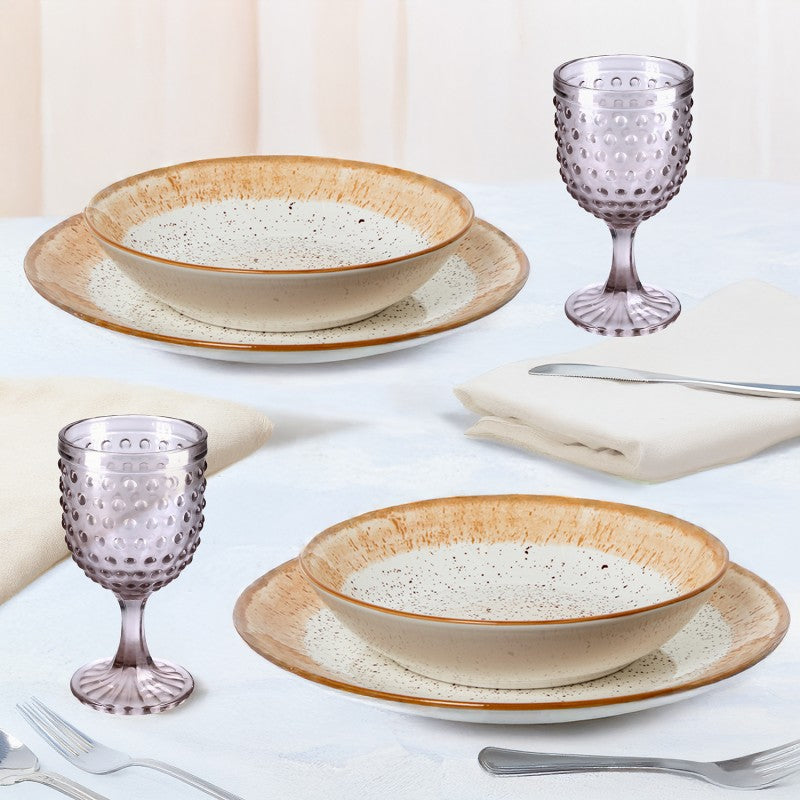 Platos hondos de porcelana con borde marrón moteado dispuestos en mesa elegante junto a copas texturizadas