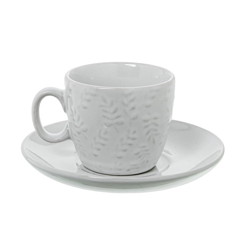 Detalle de una taza de café blanca con relieve floral y su plato a juego, vista individual