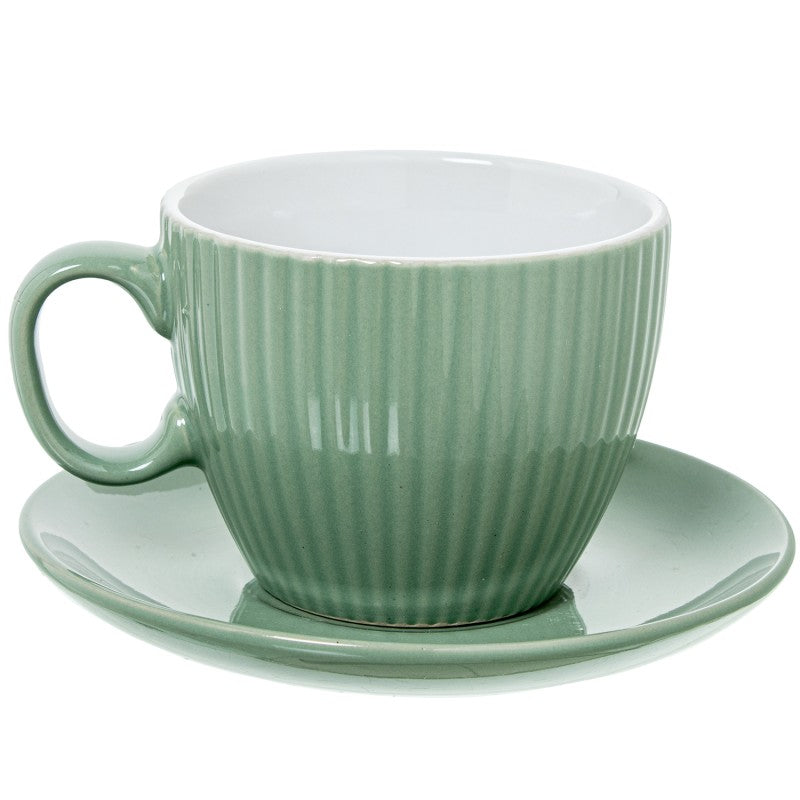 Detalle de una taza de té verde menta acanalada con su plato a juego, vista individual