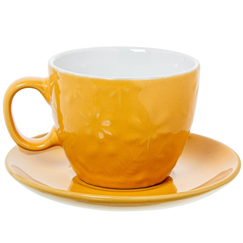 Detalle de una taza de té amarilla con su plato a juego, vista individual