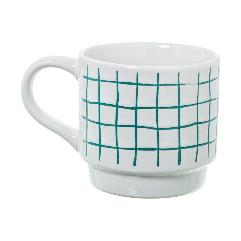 Detalle de un mug de cerámica blanca con estampado de cuadros verdes y asa