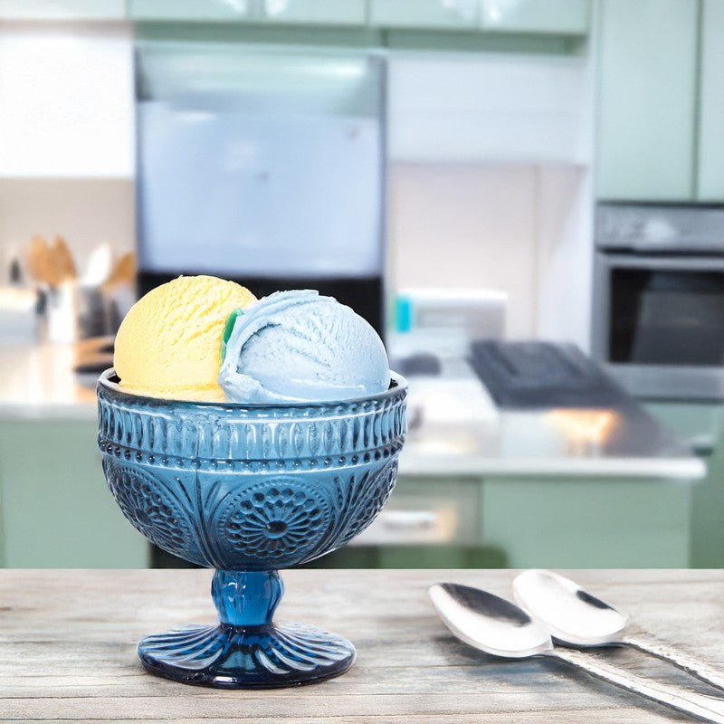 Copa de cristal azul con relieve geométrico servida con helado de vainilla y menta en cocina