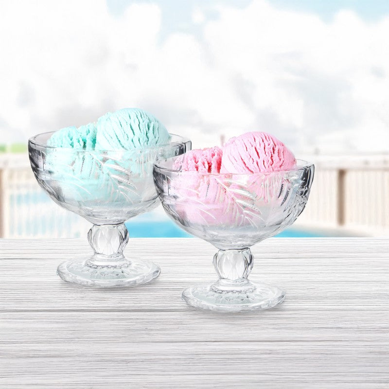 Copas de cristal transparente con relieve de hojas servidas con helado de colores al aire libre