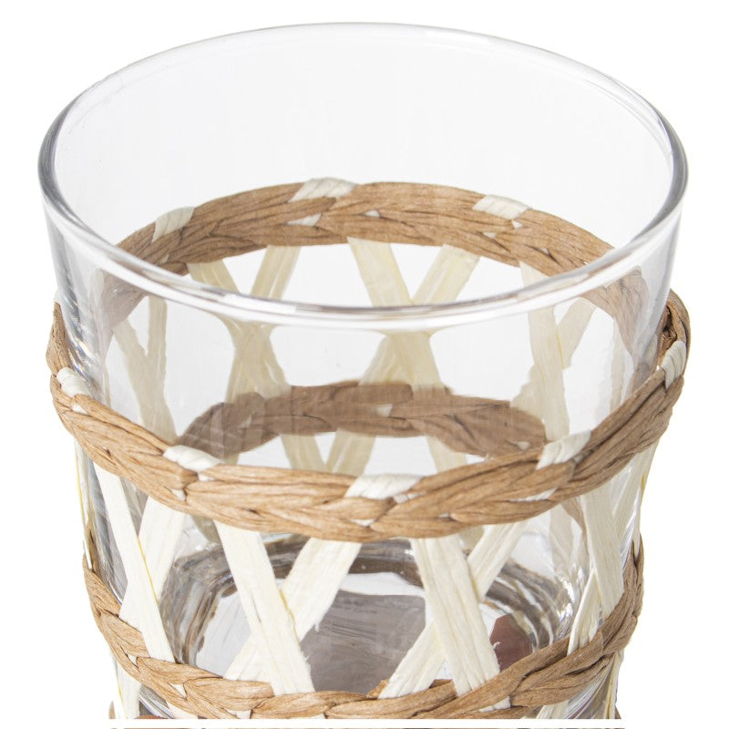 Detalle de la funda de mimbre tejida a mano en vaso bajo de cristal
