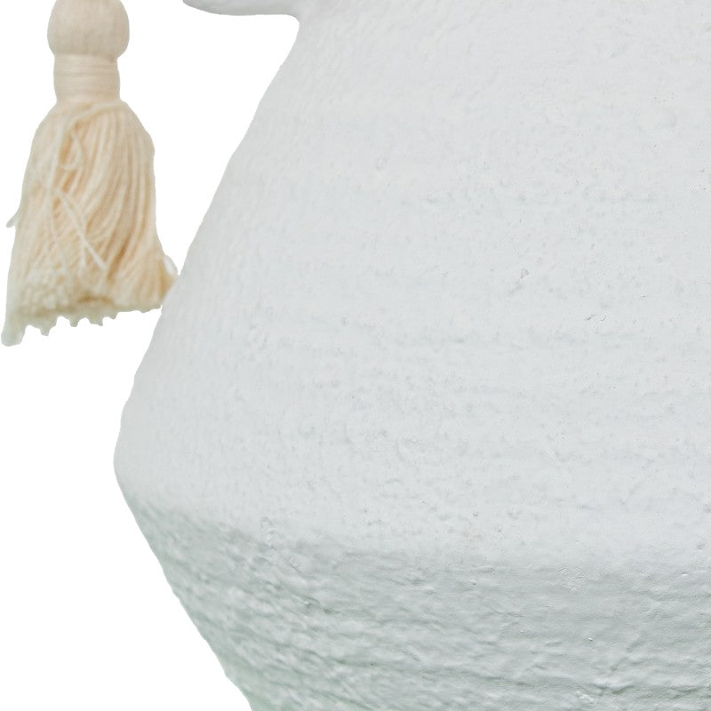 Primer plano de la textura rugosa de la base de cerámica blanca con detalle de la borla decorativa de algodón