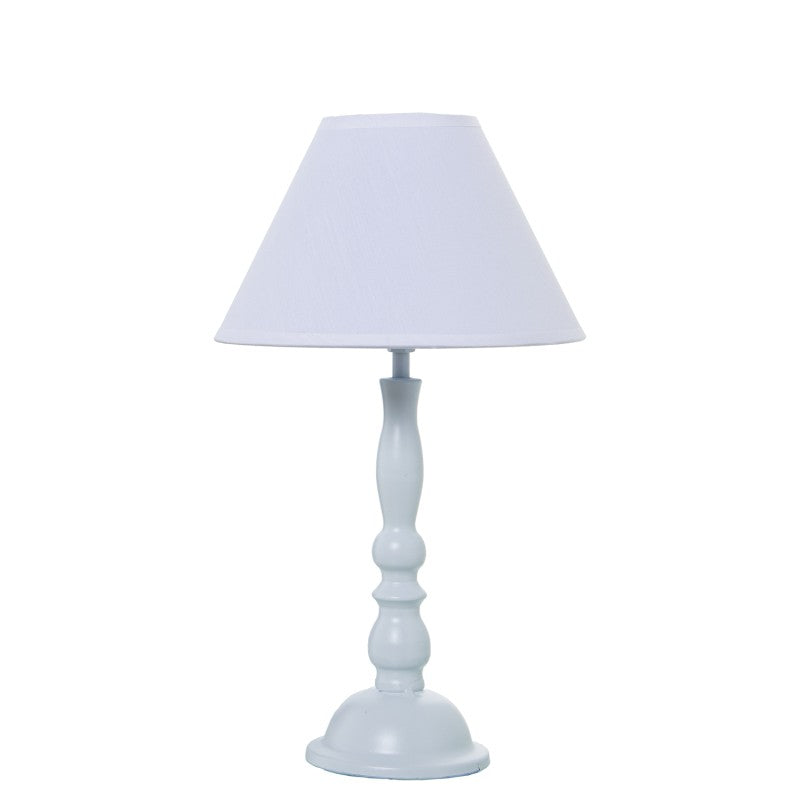 Lámpara de sobremesa de metal blanco con base torneada tipo candelabro y pantalla cónica, vista frontal