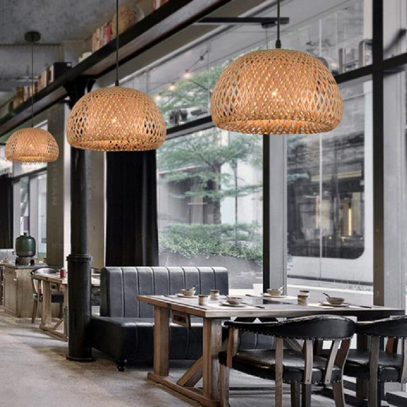 Lámparas de techo de bambú decorando un restaurante junto a ventanales y mesas de madera