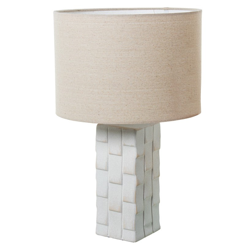 Lámpara de sobremesa con base de cerámica blanca de acabado entrelazado tipo cesta y pantalla cilíndrica beige, vista frontal