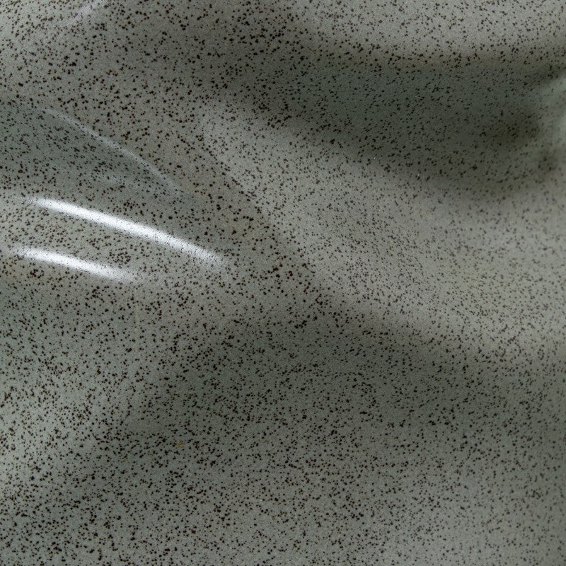 Primer plano del esmalte gris moteado y brillante de la base ondulada de cerámica