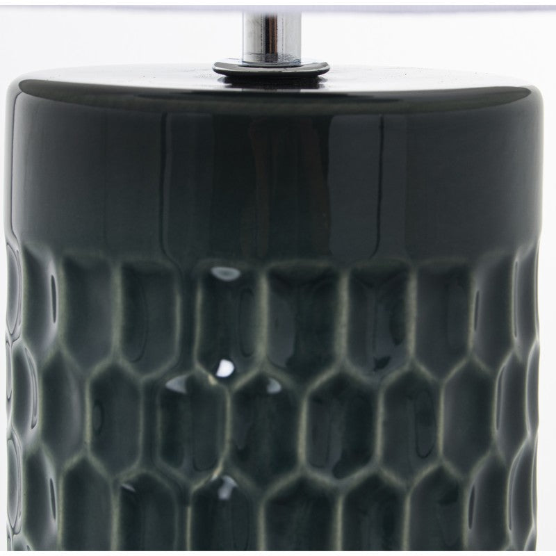 Primer plano de la parte superior de la base de cerámica azul petróleo con patrón hexagonal en relieve y tubo metálico