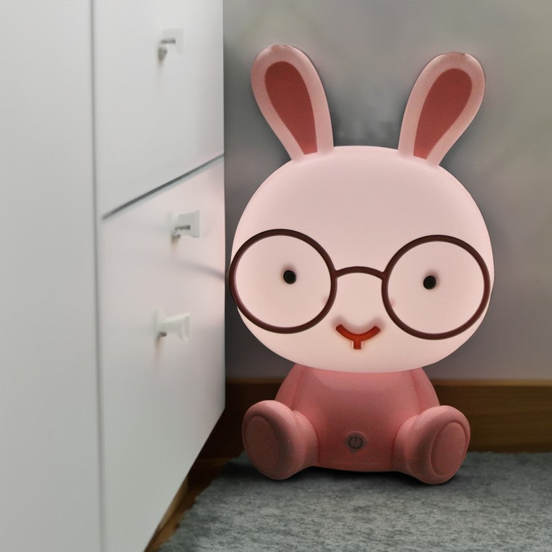 Lámpara conejo rosa encendida decorando un rincón junto a un mueble