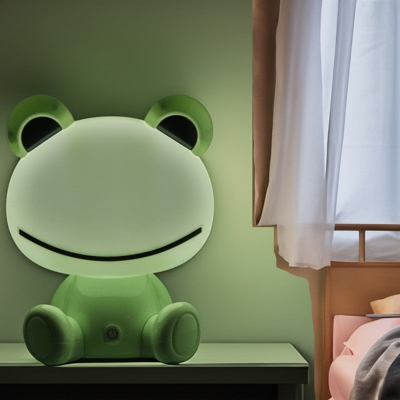 Lámpara rana encendida decorando una mesita junto a la ventana en un dormitorio infantil
