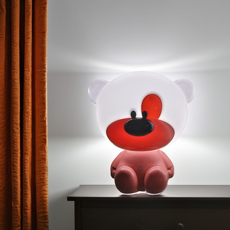 Lámpara osito rosa encendida junto a una cortina, mostrando el brillo cálido de la luz LED