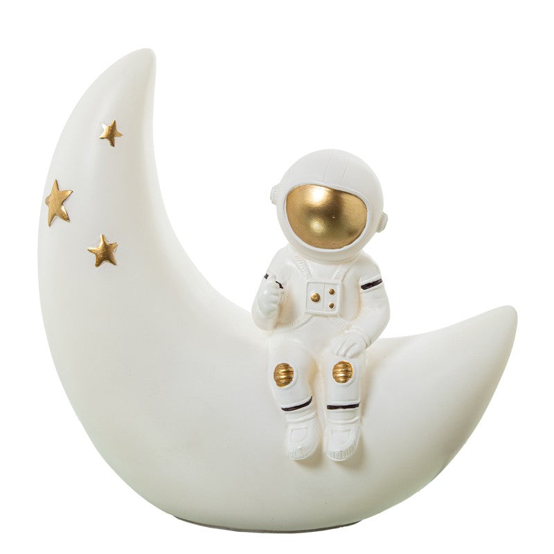 Lámpara LED con figura de astronauta sentado sobre una luna, acabado blanco y dorado