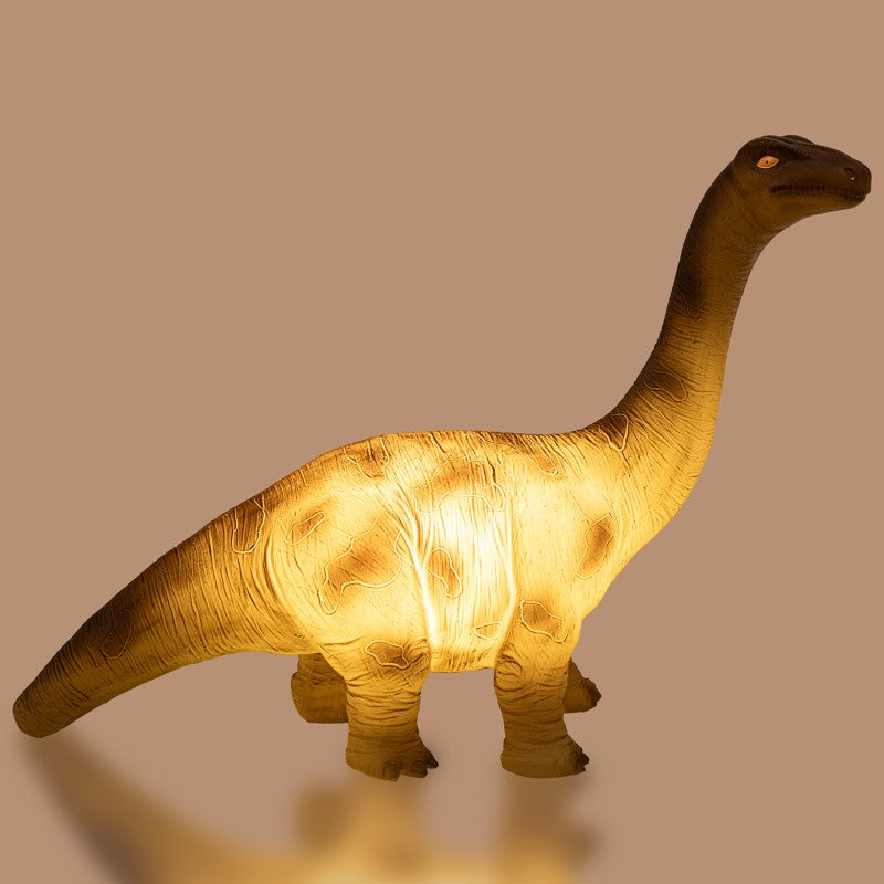 Lámpara dinosaurio encendida mostrando el brillo cálido de la luz LED interior