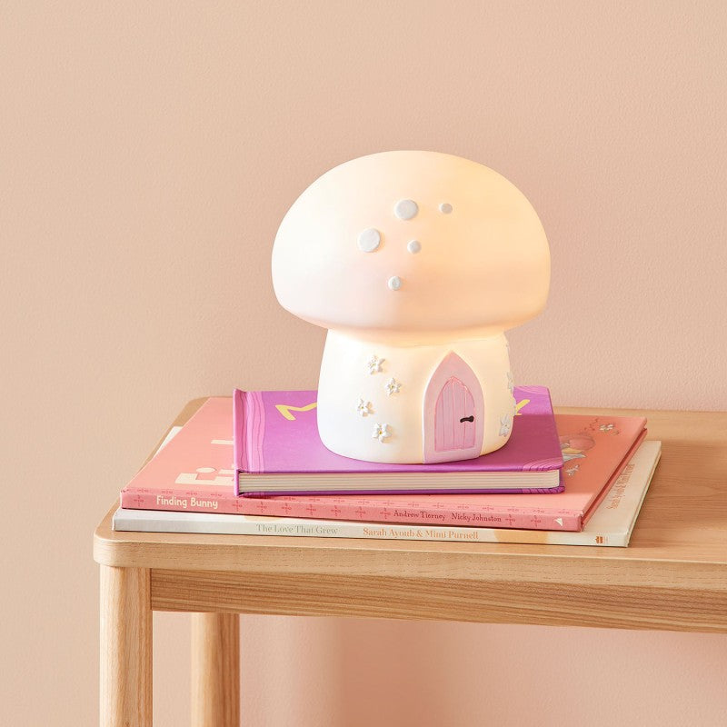 Lámpara seta encendida decorando una mesita infantil con libros de cuentos