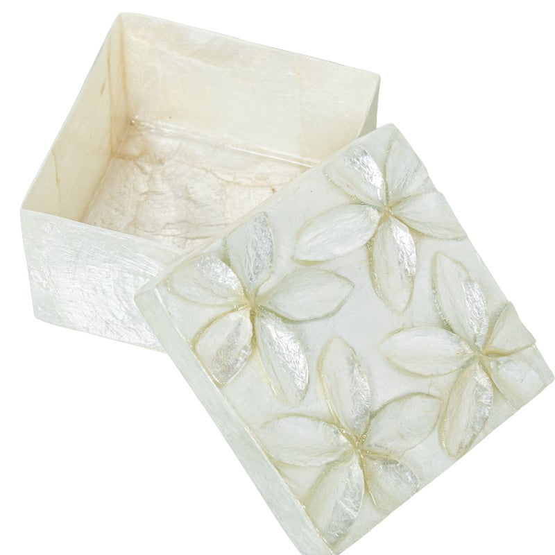 Caja de nácar abierta mostrando el interior blanco y la tapa con flores en relieve