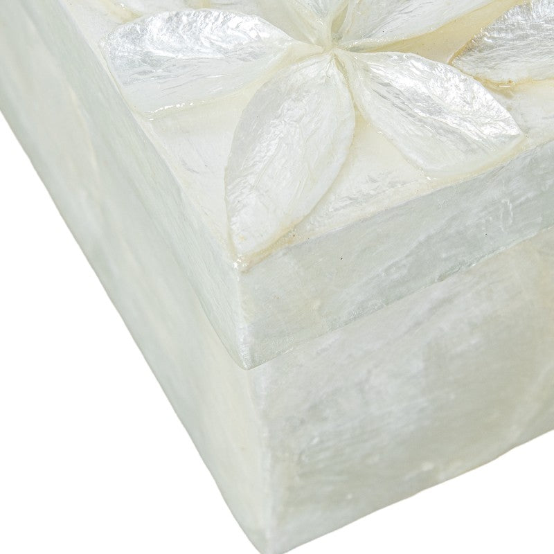 Detalle en primer plano de la flor de nácar tallada en la esquina de la caja