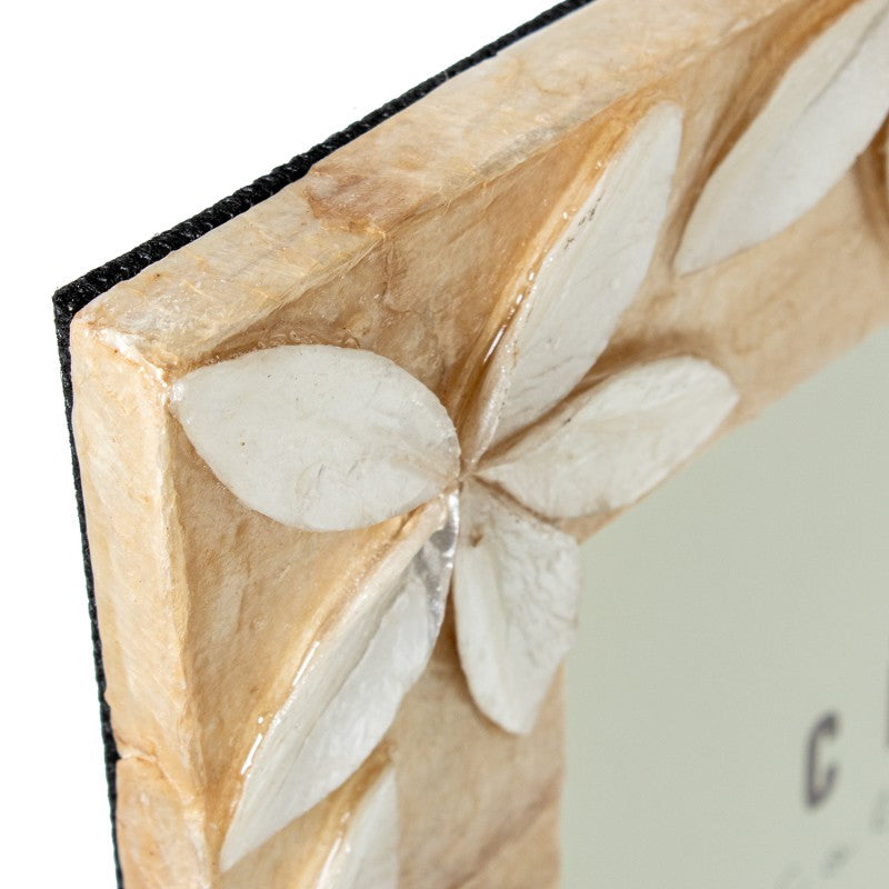 Detalle de la esquina del portafotos con flor de nácar tallada en relieve