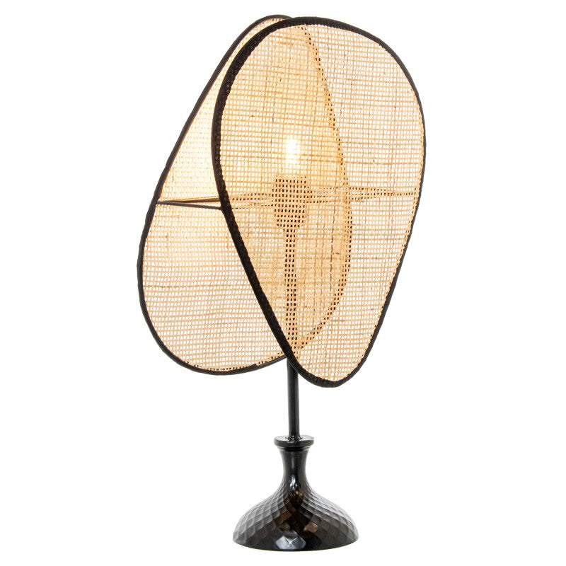 Lámpara de sobremesa encendida mostrando la bombilla iluminando entre los pétalos de ratán tejido