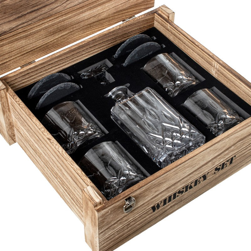 Set de whisky abierto mostrando botella, 4 vasos de cristal y piedras enfriadoras en caja de madera
