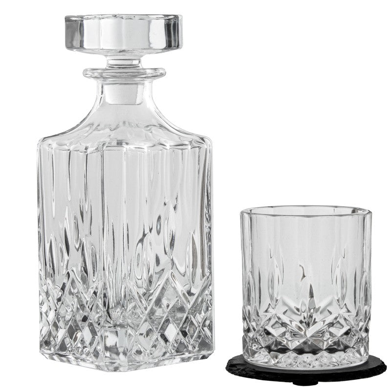 Botella decantadora de cristal tallado junto a un vaso de whisky a juego