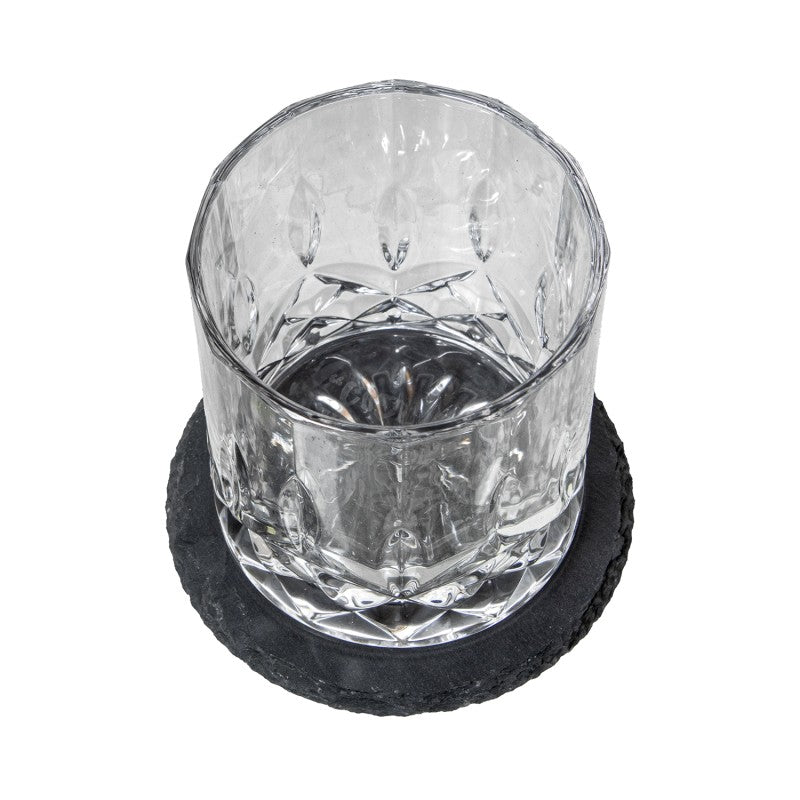 Vaso de whisky de cristal tallado sobre posavasos de pizarra