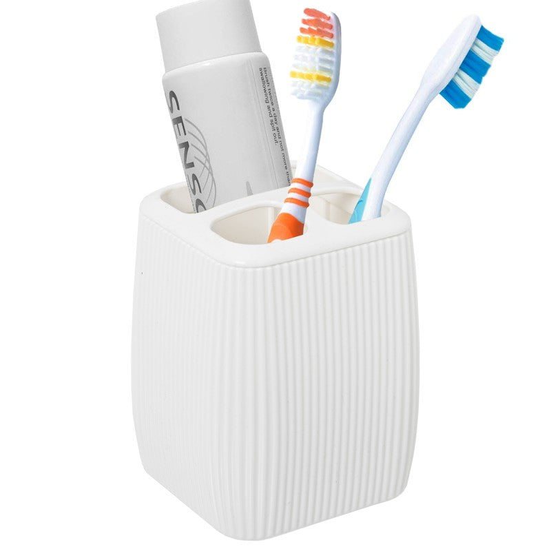 Vaso porta cepillos de dientes con cepillos y pasta dental, en uso